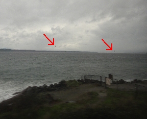 Two paragrliders out over the water
